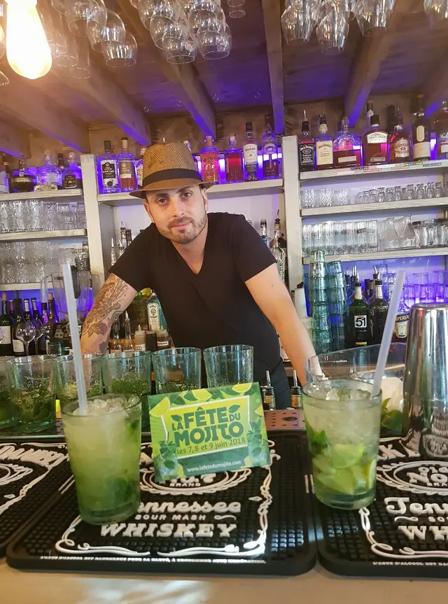 Un barman prépare des mojitos derrière son comptoir pendant la Fête du Mojito 2018